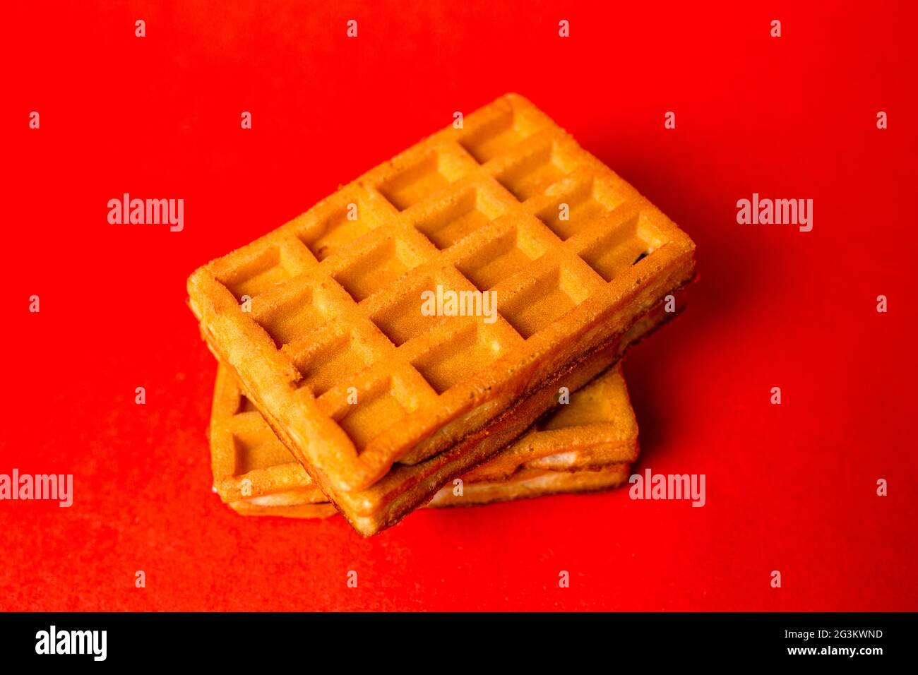 waffle belgi con ripieno su sfondo rosso Foto Stock