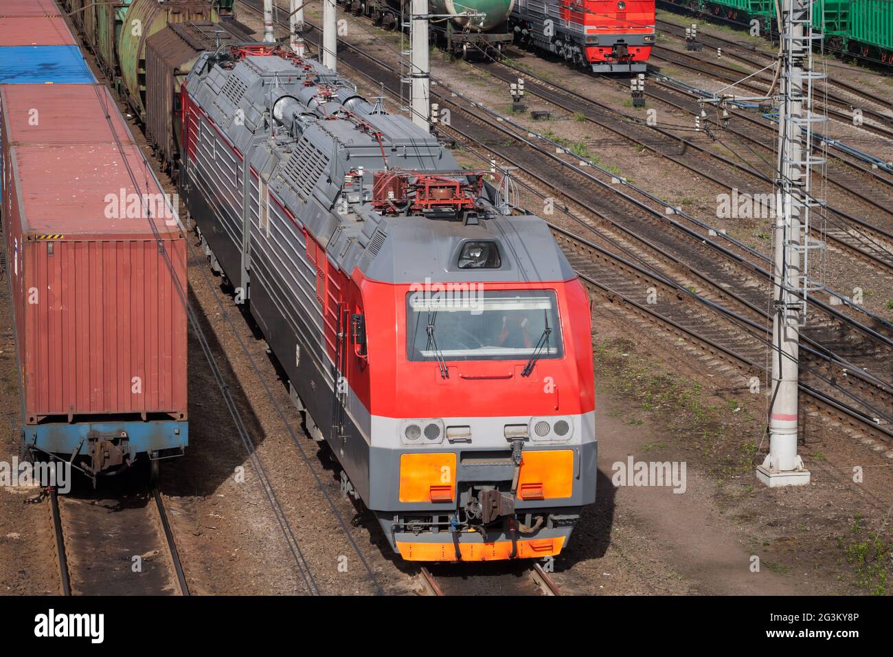 La moderna locomotiva elettrica diesel rossa si trova su una ferrovia in una giornata di sole Foto Stock
