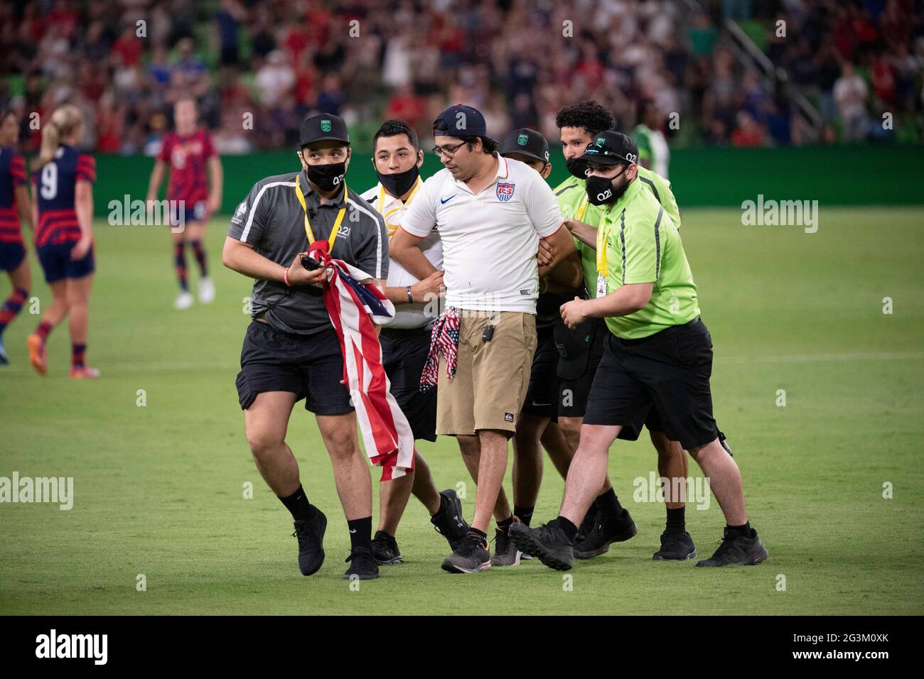 Austin, Texas, USA, 16 2021 giugno: La sicurezza detesta un uomo che ha tentato di correre sul campo di gioco alla fine della vittoria del US Women's National Team (USWNT) 2-0 sulla Nigeria, nella prima partita al Q2 Stadium di Austin. La squadra femminile degli Stati Uniti, una delle preferite delle Olimpiadi, sta chiudendo una serie di partite estive per preparare i Giochi di Tokyo. La stampa ha segnato un gol nella vittoria per il calcio degli Stati Uniti. Credit: Bob Daemmrich/Alamy Live News Foto Stock