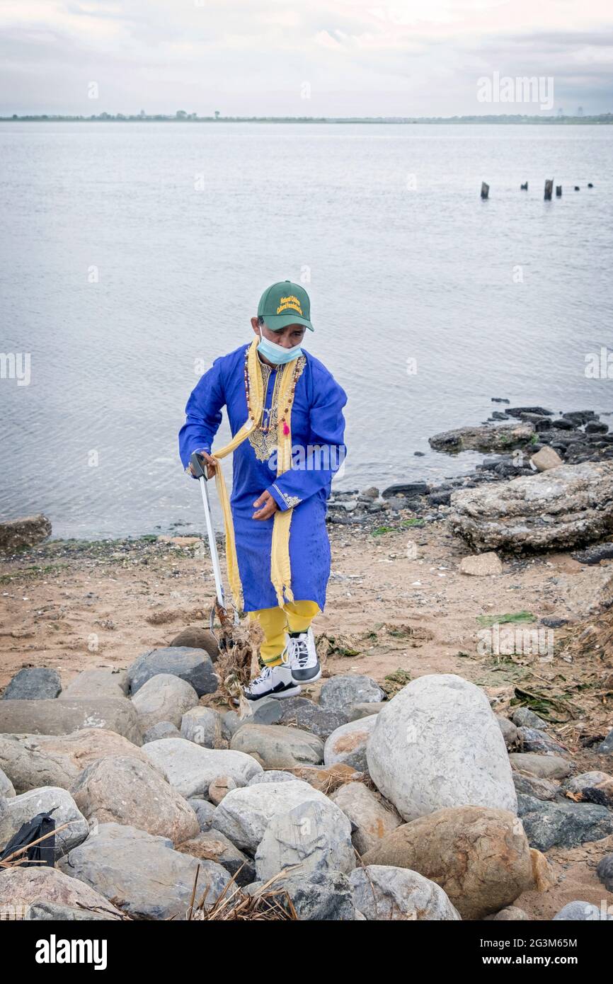 Un sacerdote indù volontari pulire la spiaggia a Jamaica Bay in Queens come parte del progetto 2021 Primhvi Beach Cleanup. Imn Queens, New York. Foto Stock