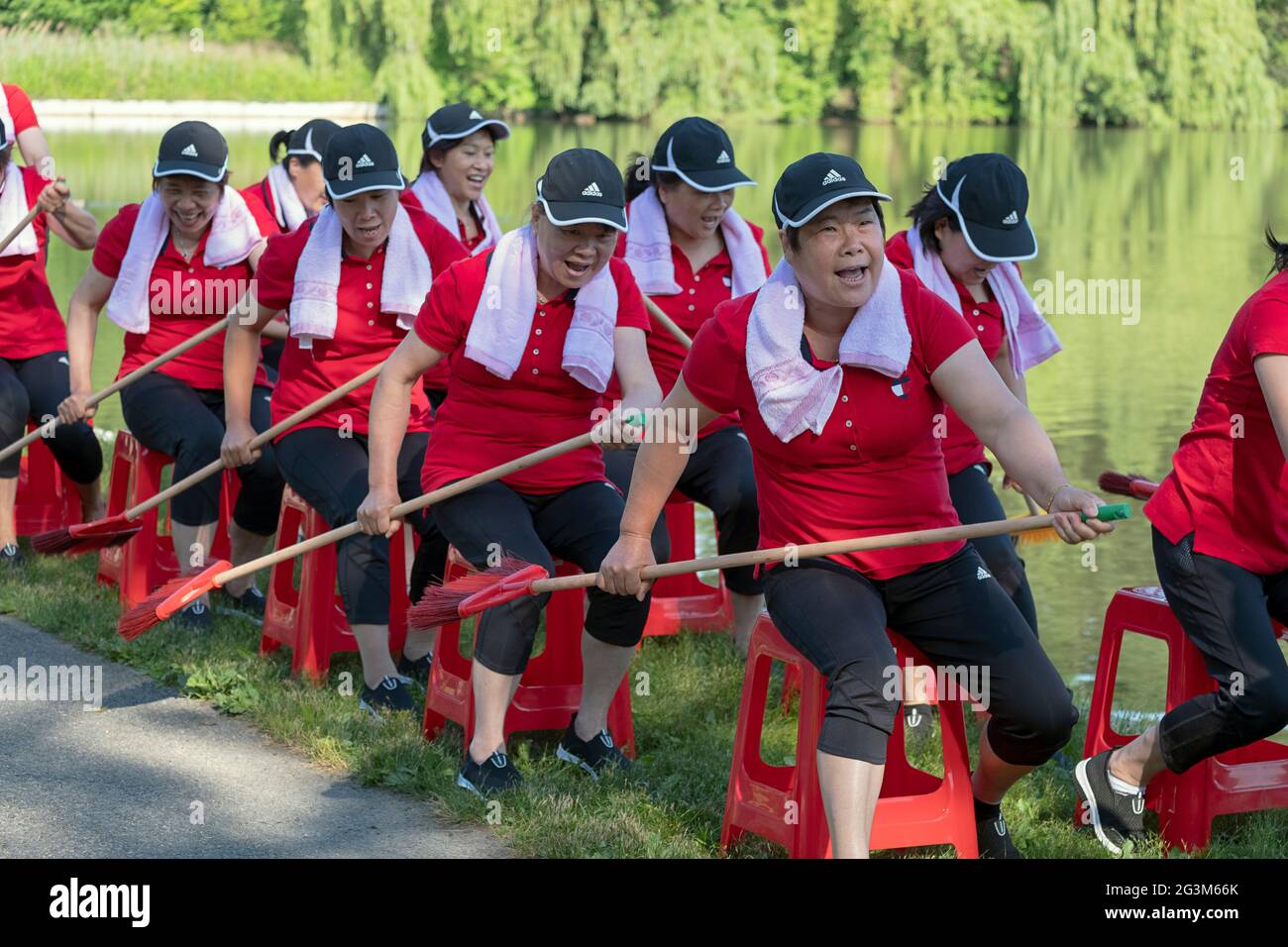 Artisti di danza cinese americana di mezza età provano una routine di canottaggio in un parco a Flushing, Queens, New York City Foto Stock