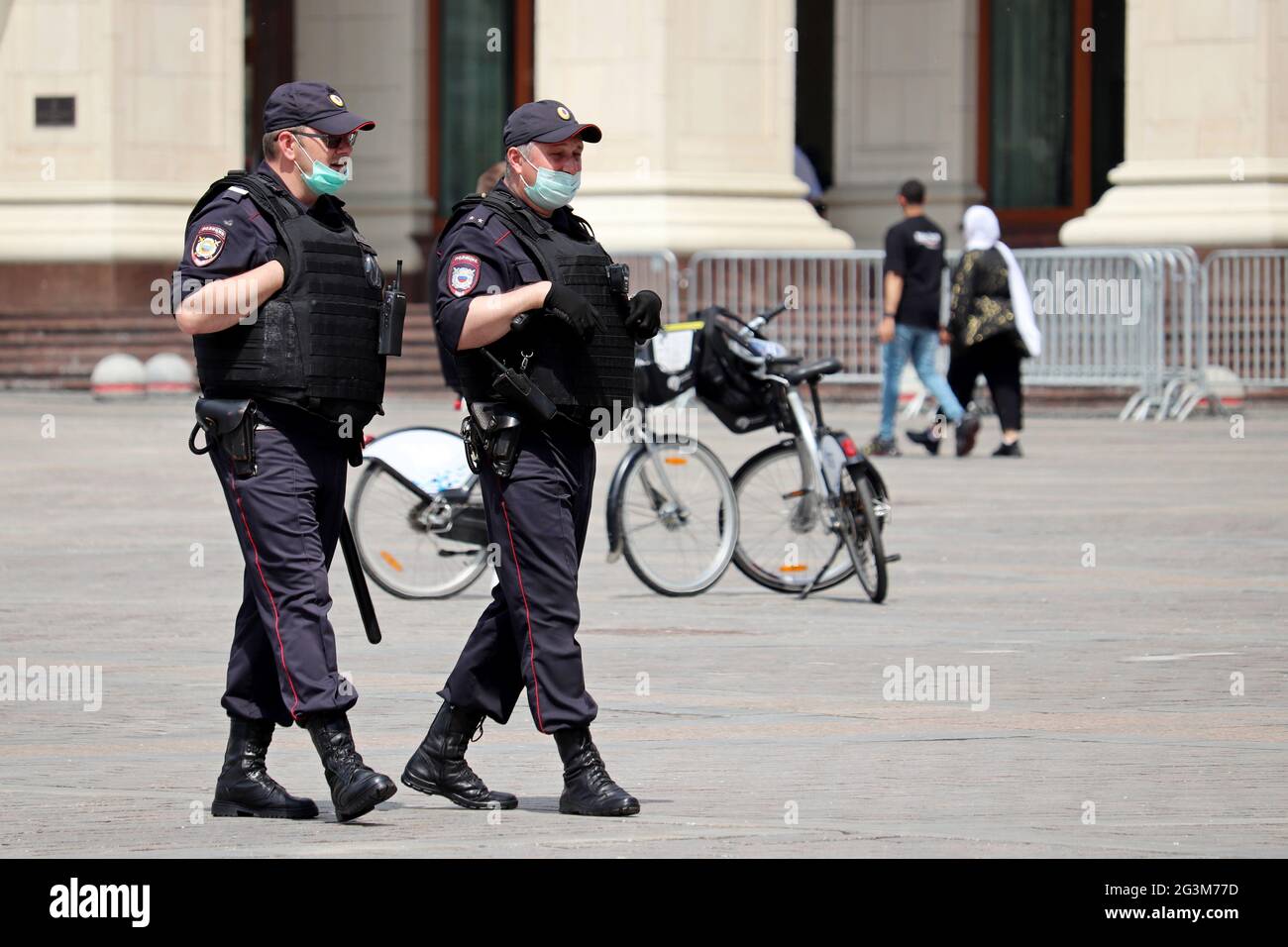 Ufficiali di polizia russi in maschere di faccia e gilet antproiettile pattugliano la strada. Sicurezza degli eventi di massa durante il coronavirus Foto Stock