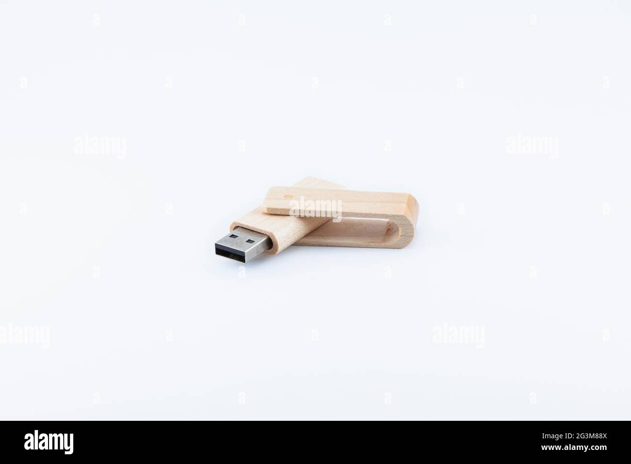 L'unità penna in legno è posizionata su uno sfondo bianco e si apre con un angolo ottuso con il connettore USB rivolto verso sinistra. Foto Stock