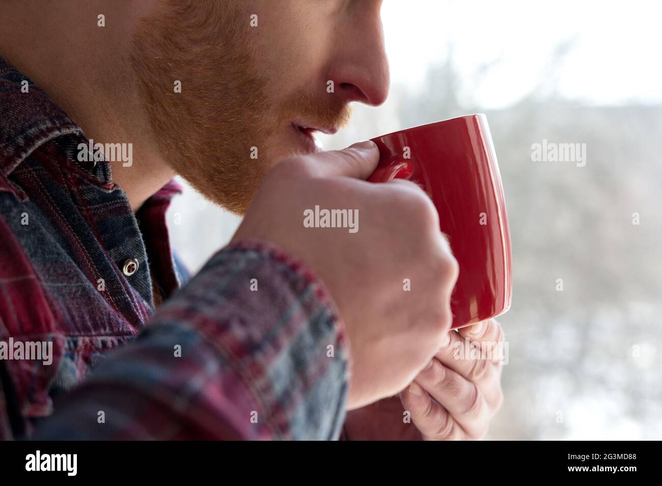 Uomo che prende sorso dalla tazza. Foto Stock