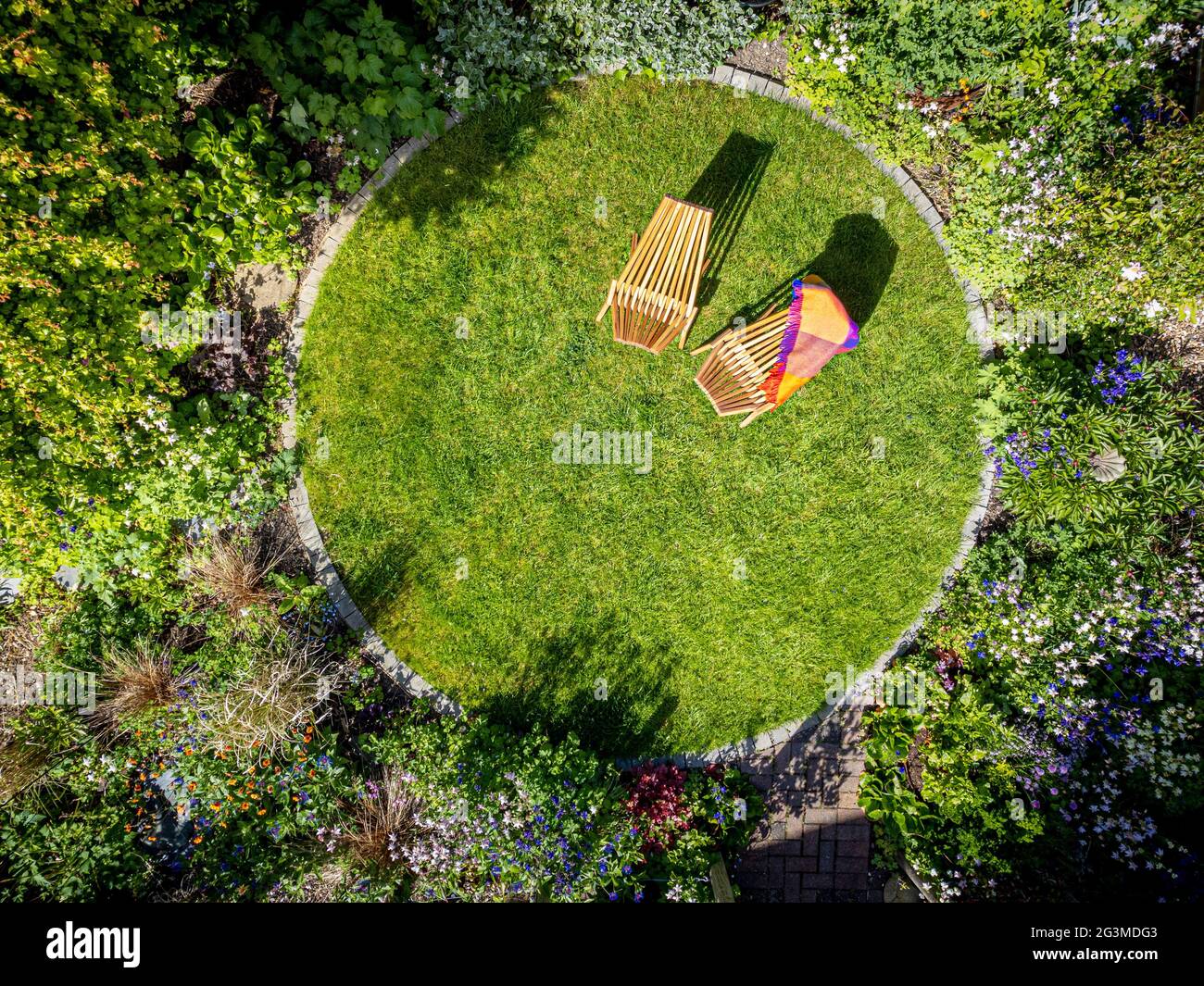 Foto aerea del giardino domestico con prato circolare e due sedie a sdraio in legno Foto Stock