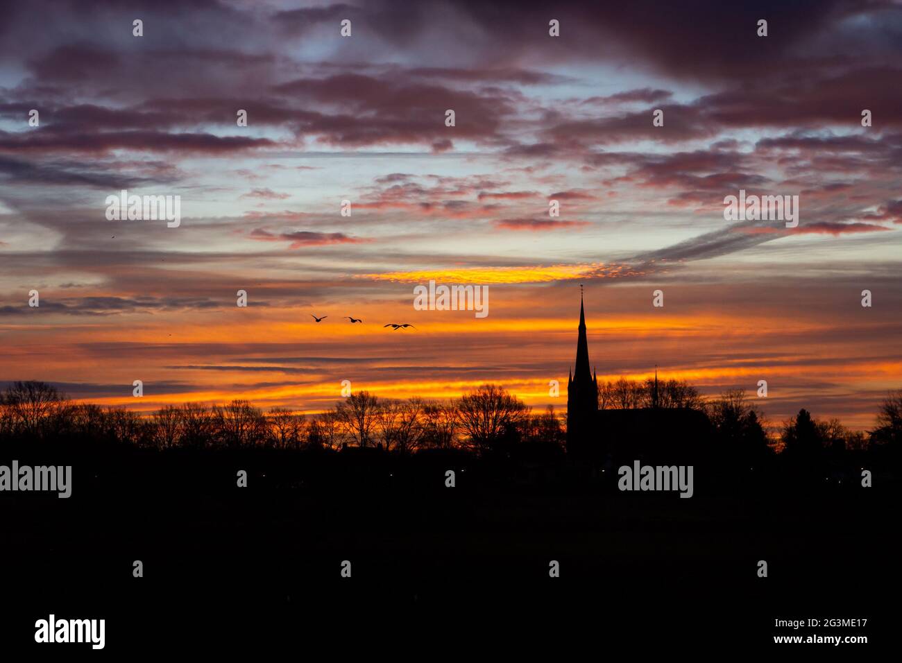 Chiesa edificio esterno silhouette con un cielo colorato alba nella Provincia Nord Brabante, Paesi Bassi Foto Stock