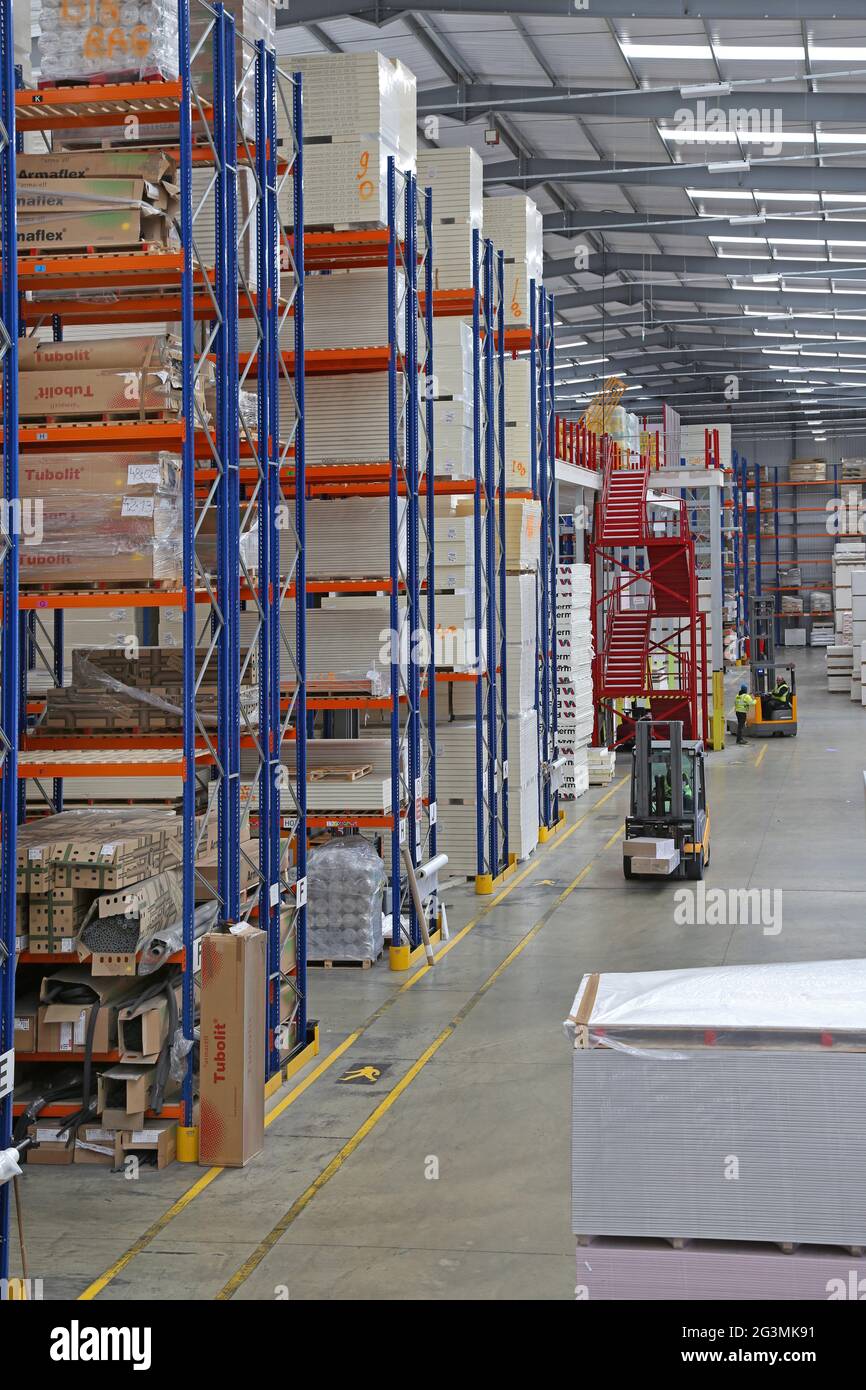 Interno di un enorme magazzino di materiali e prodotti da costruzione a Londra Ovest, Regno Unito. Mostra i ripiani impilati e i carrelli elevatori a forche. Nessuna carenza di scorte. Foto Stock