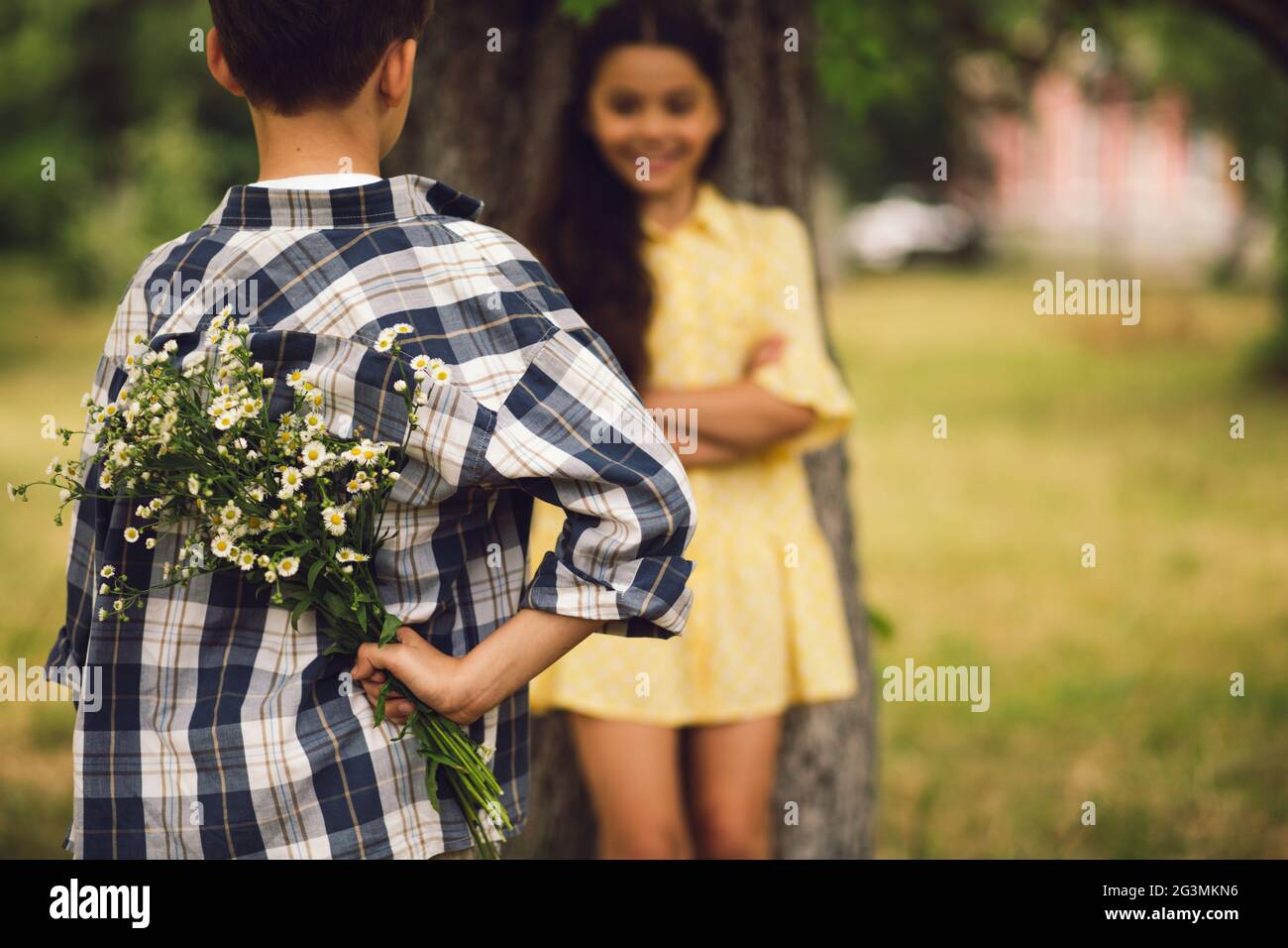 Little Boy dando bouqet di fiori a ragazza. Foto Stock