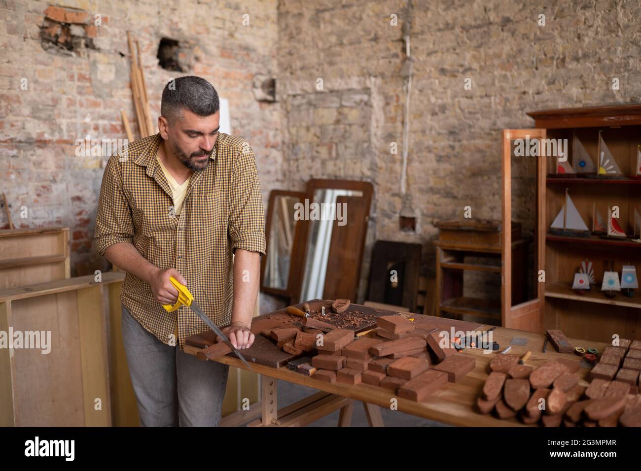 Esperto falegname taglia un pezzo di legno Foto Stock