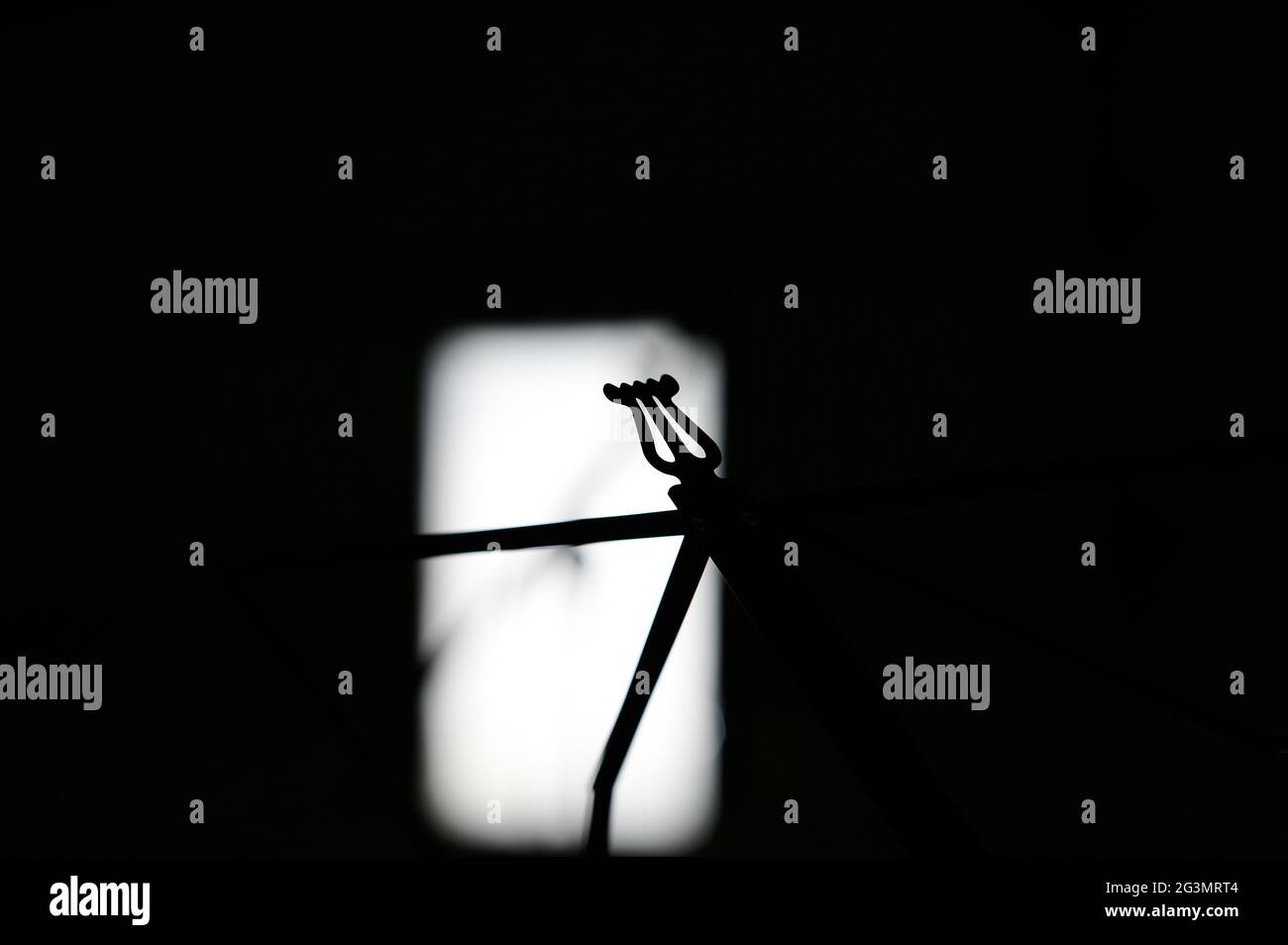 Un supporto musicale in silhouette su sfondo nero Foto Stock