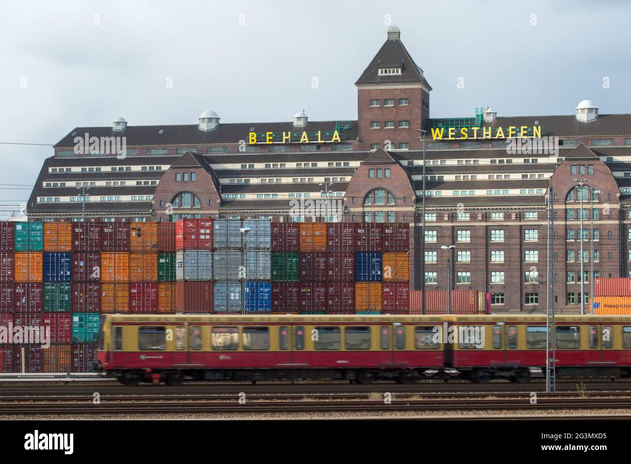 '13.04.2021, Berlino, Berlino, Germania - Mitte - magazzino del Westhafen a Berlino-Moabit con container e ferrovia suburbana del Ringbahn. 0CE21 Foto Stock