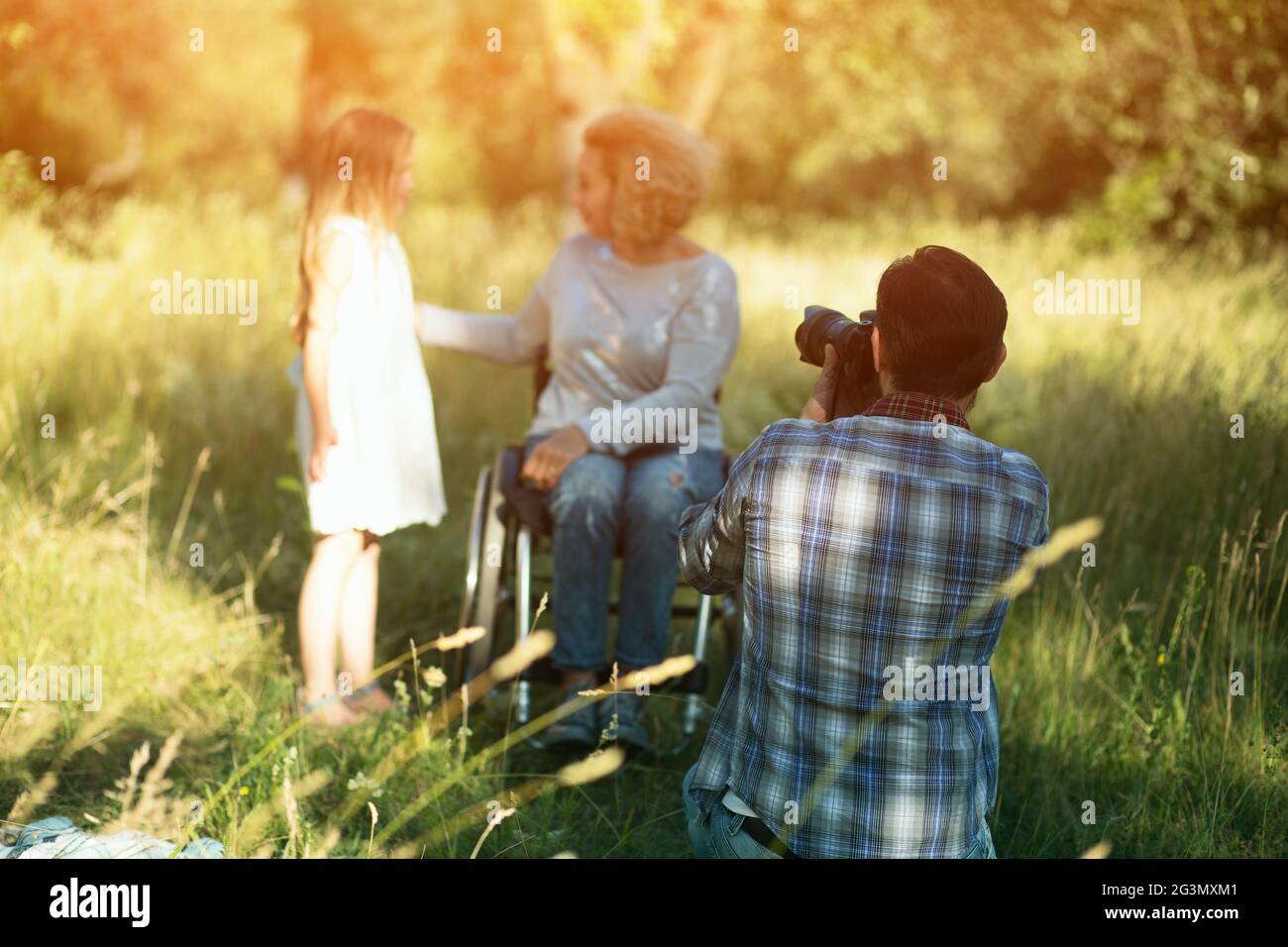 Professianl fotografo prende foto di donna in sedia a rotelle Foto Stock