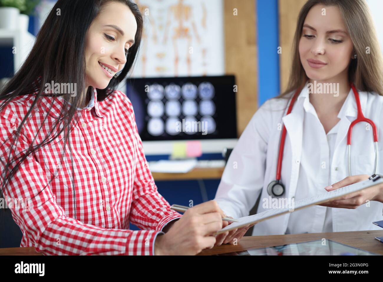 Sorridente paziente femminile segno forma medica alla clinica incontro con il medico Foto Stock