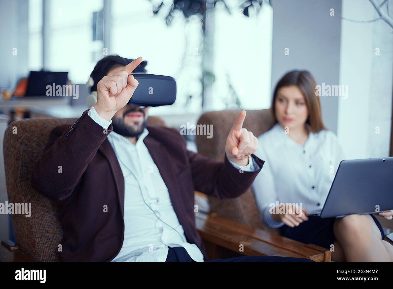 Adulto Uomo Barbuto con la realtà virtuale vr bicchieri con la donna in ufficio Foto Stock