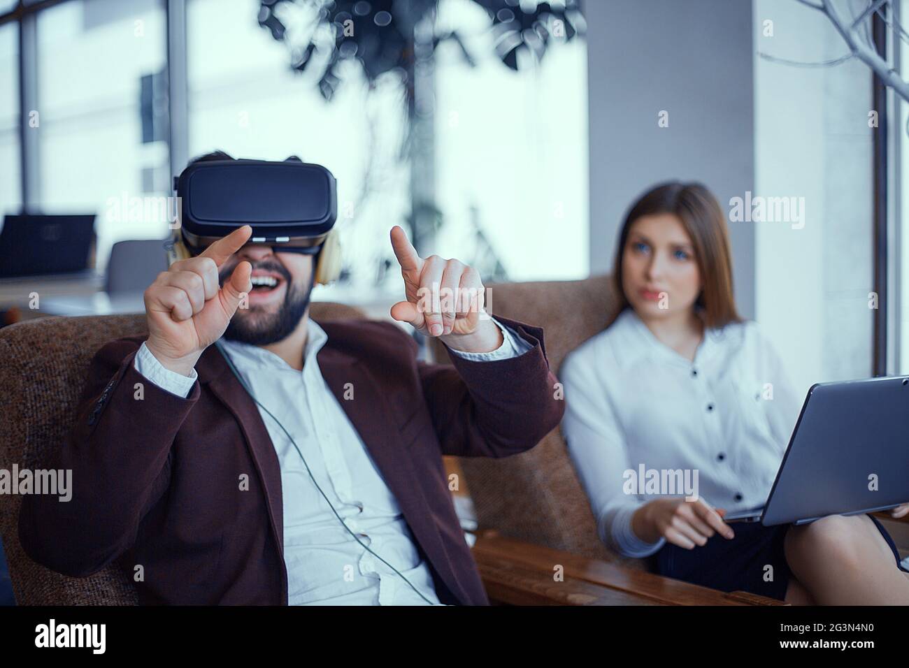 Adulto Uomo Barbuto con la realtà virtuale vr bicchieri con la donna in ufficio Foto Stock