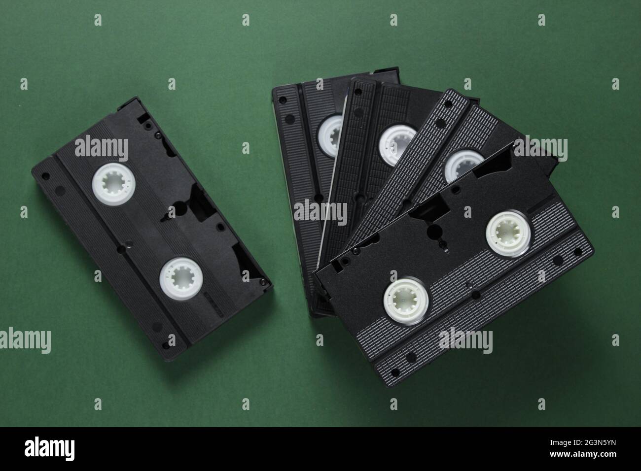 Pila di videocassette retrò su sfondo verde. Vista dall'alto Foto Stock