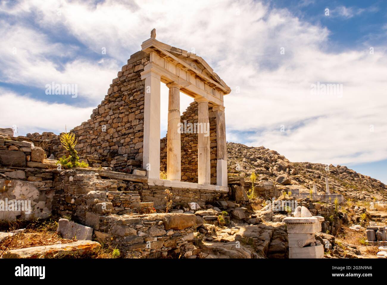 Ben conservato Tempio di Iside vista laterale sull'isola di Delos situato sulla collina sopra l'antica città con cielo blu e le nuvole sullo sfondo, la Grecia. Foto Stock
