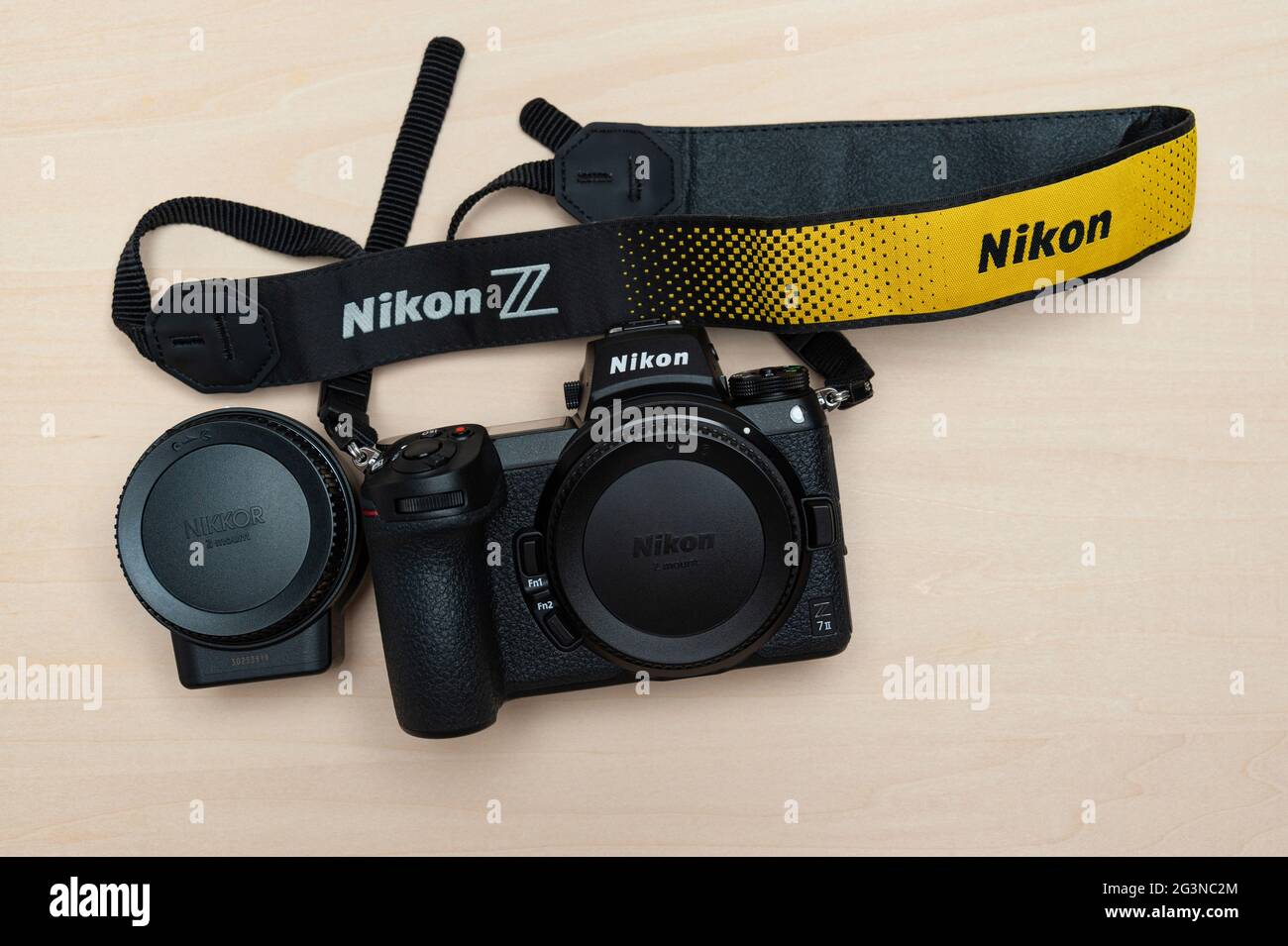 Corpo fotocamera digitale mirrorless Nikon Z 7II con tracolla e adattatore di montaggio FTZ. Isolato su sfondo di legno. Vista dall'alto. Foto Stock