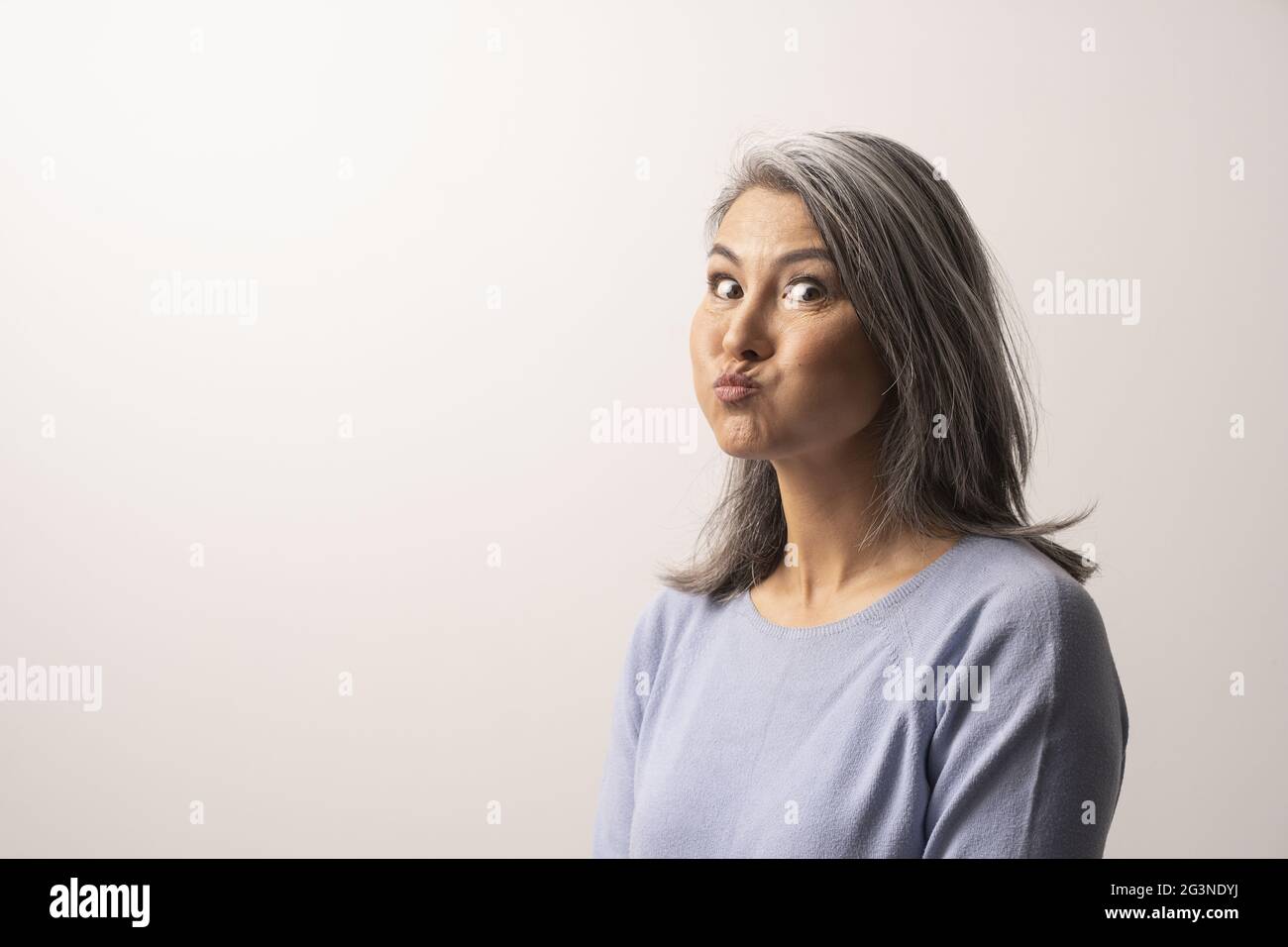 Bella donna matura è facendo facce buffe Foto Stock