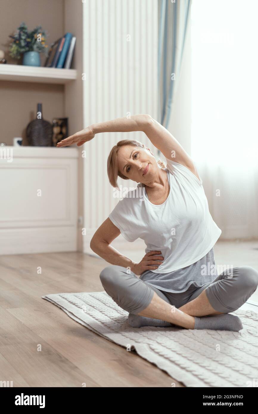 Allegra donna matura facendo esercizi yoga Foto Stock