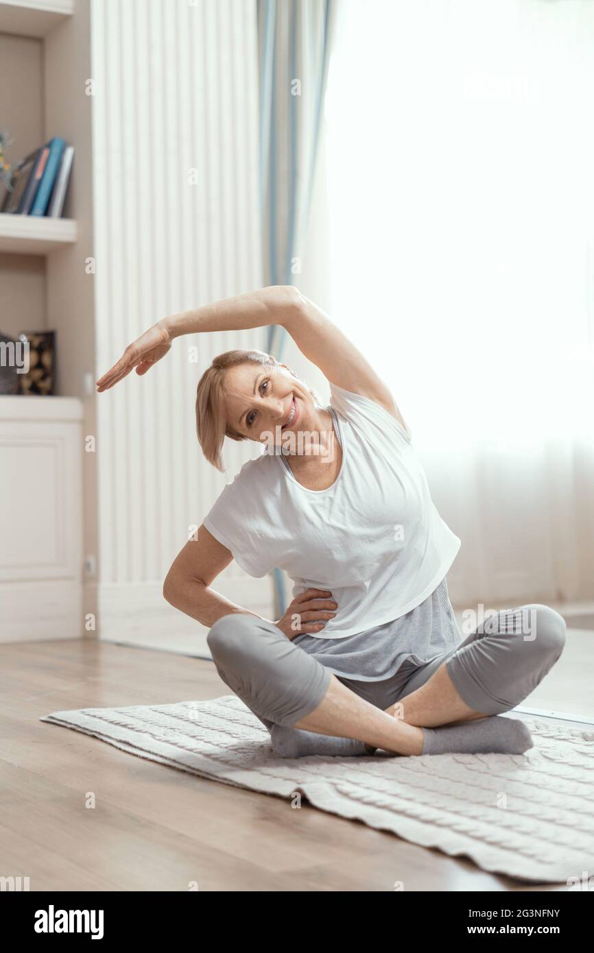 Allegra donna matura facendo esercizi yoga Foto Stock