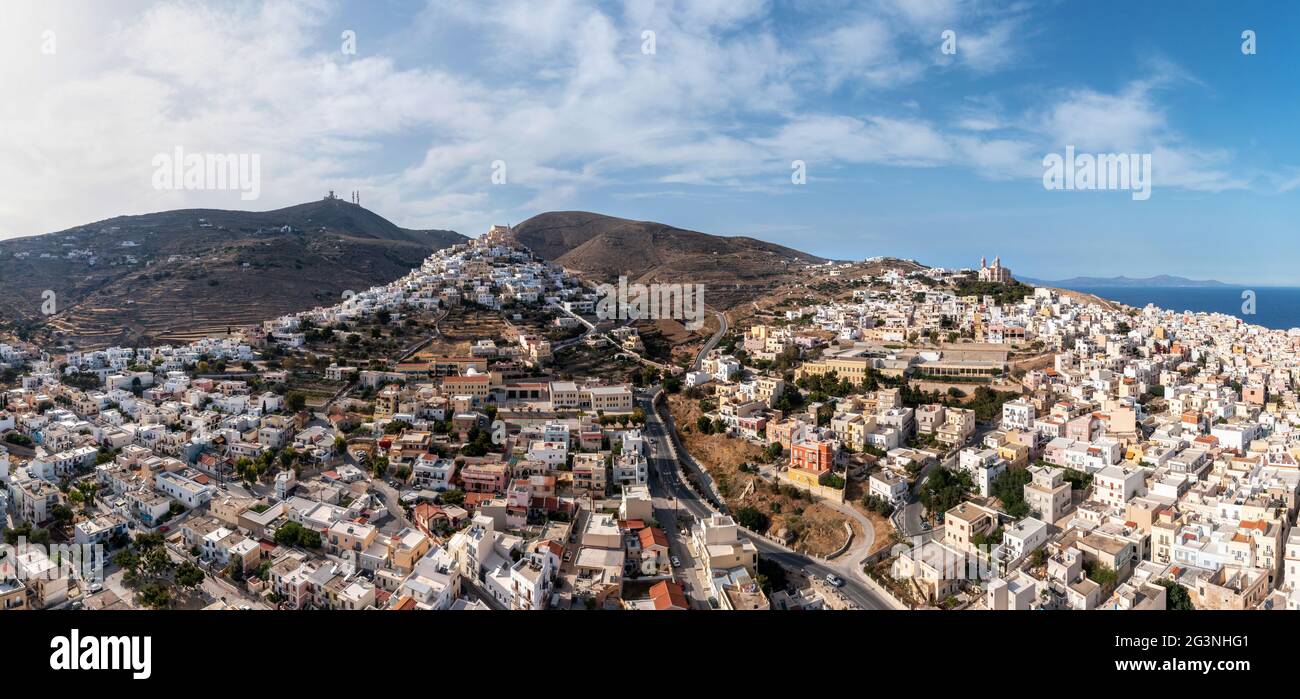 Isola di Syros, Grecia, la capitale delle Cicladi Ermoupolis panorama urbano, Ano Siros o vista panoramica città di Syra drone, cielo nuvoloso sfondo blu. Foto Stock
