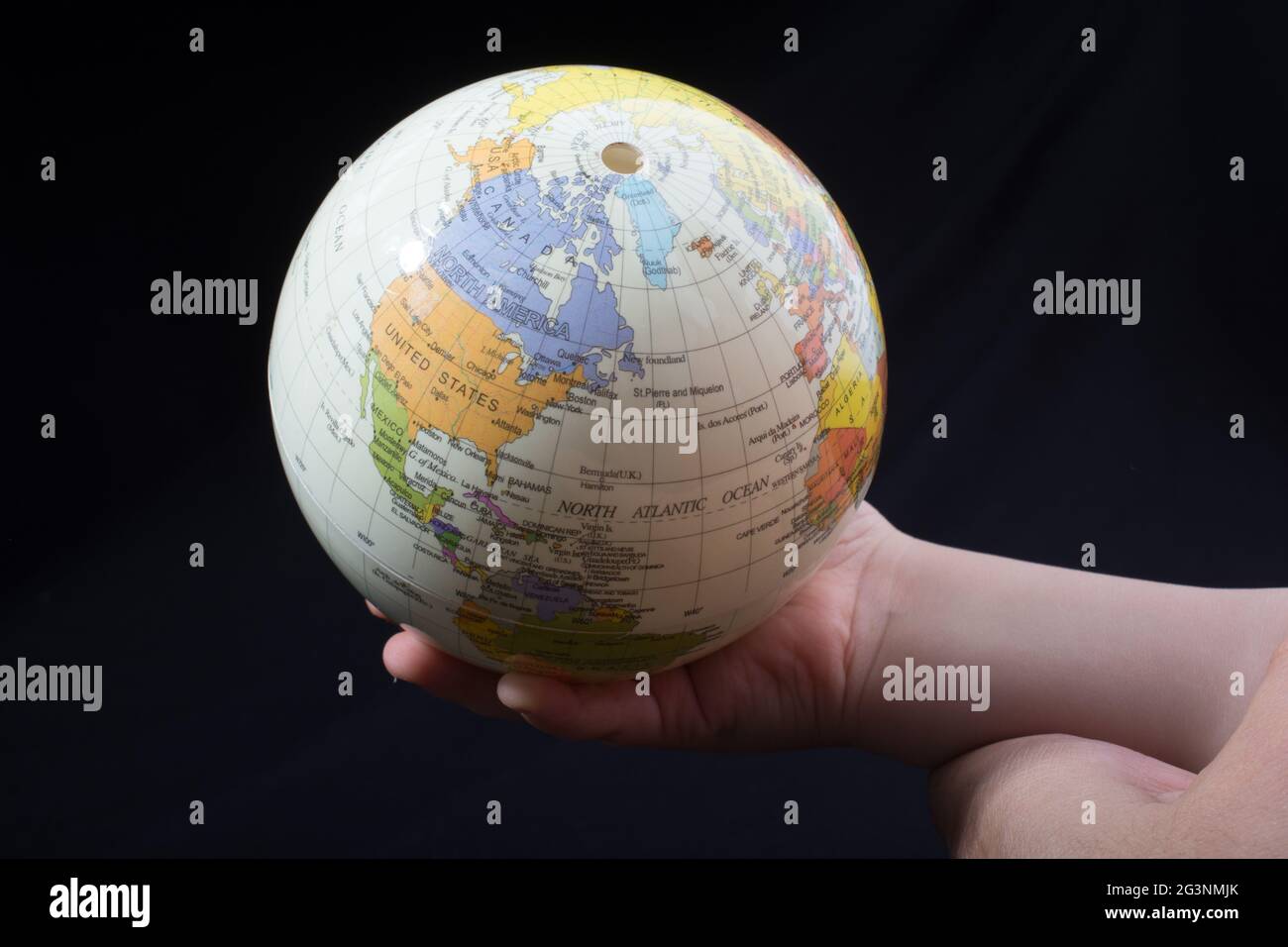 Mano tenendo un globo con la mappa su di esso Foto Stock