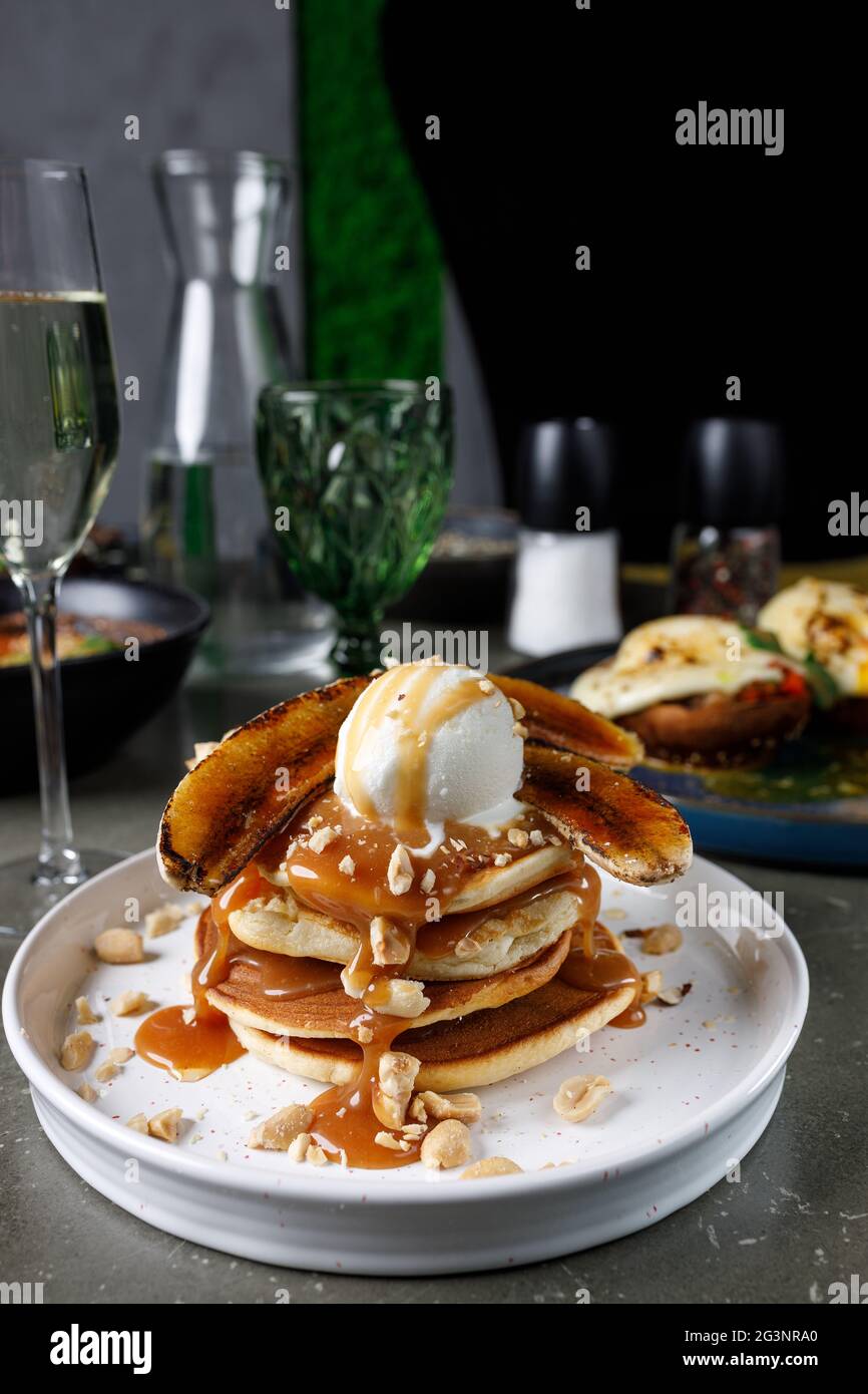 Frittelle con banana, caramello e paletta per gelato Foto Stock