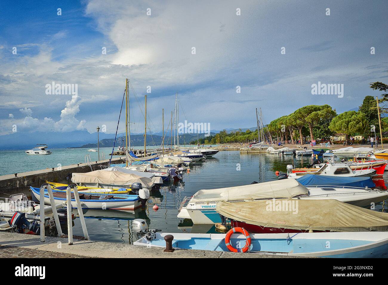 porto al lago di garda con barche, molo e suggestivo closky blu Foto Stock