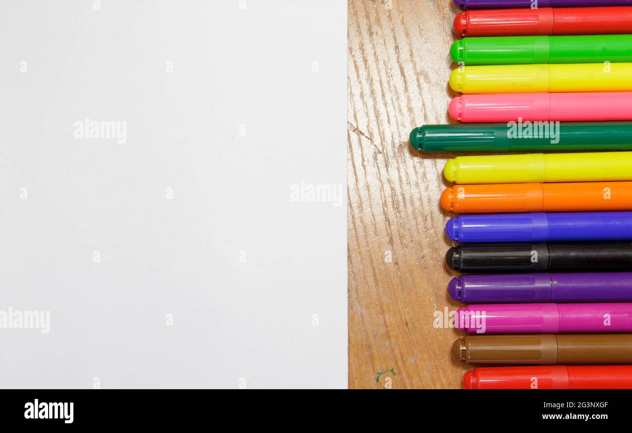 Un set di marcatori colorati e un foglio di carta bianca sul tavolo. Foto Stock