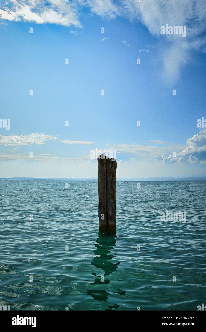 pallido in blu lago di garda acqua, blu nuvoloso cielo drammatico con orizzonte Foto Stock