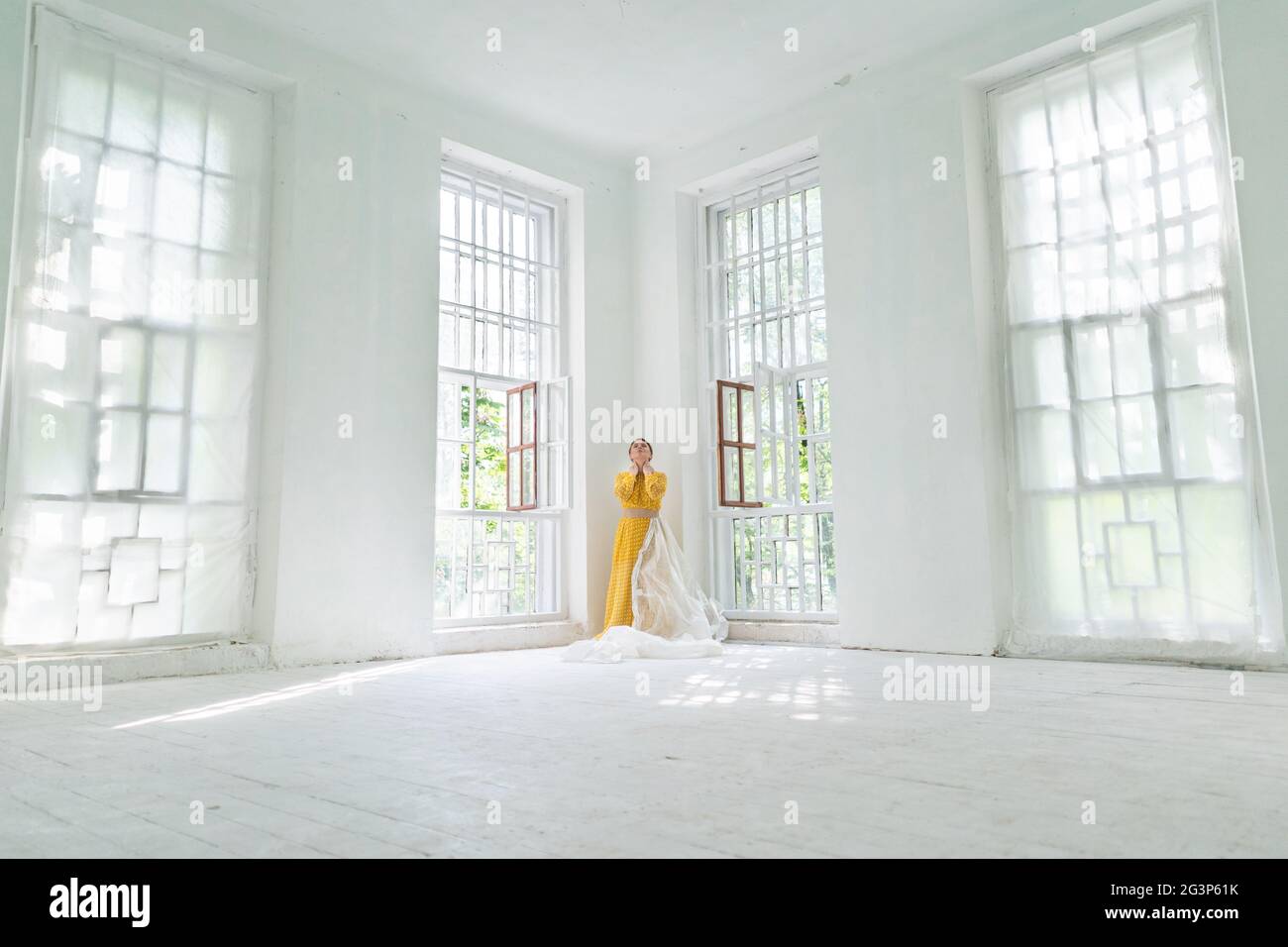 La solitudine del concetto. Una donna in abito giallo è in piedi in un angolo Foto Stock