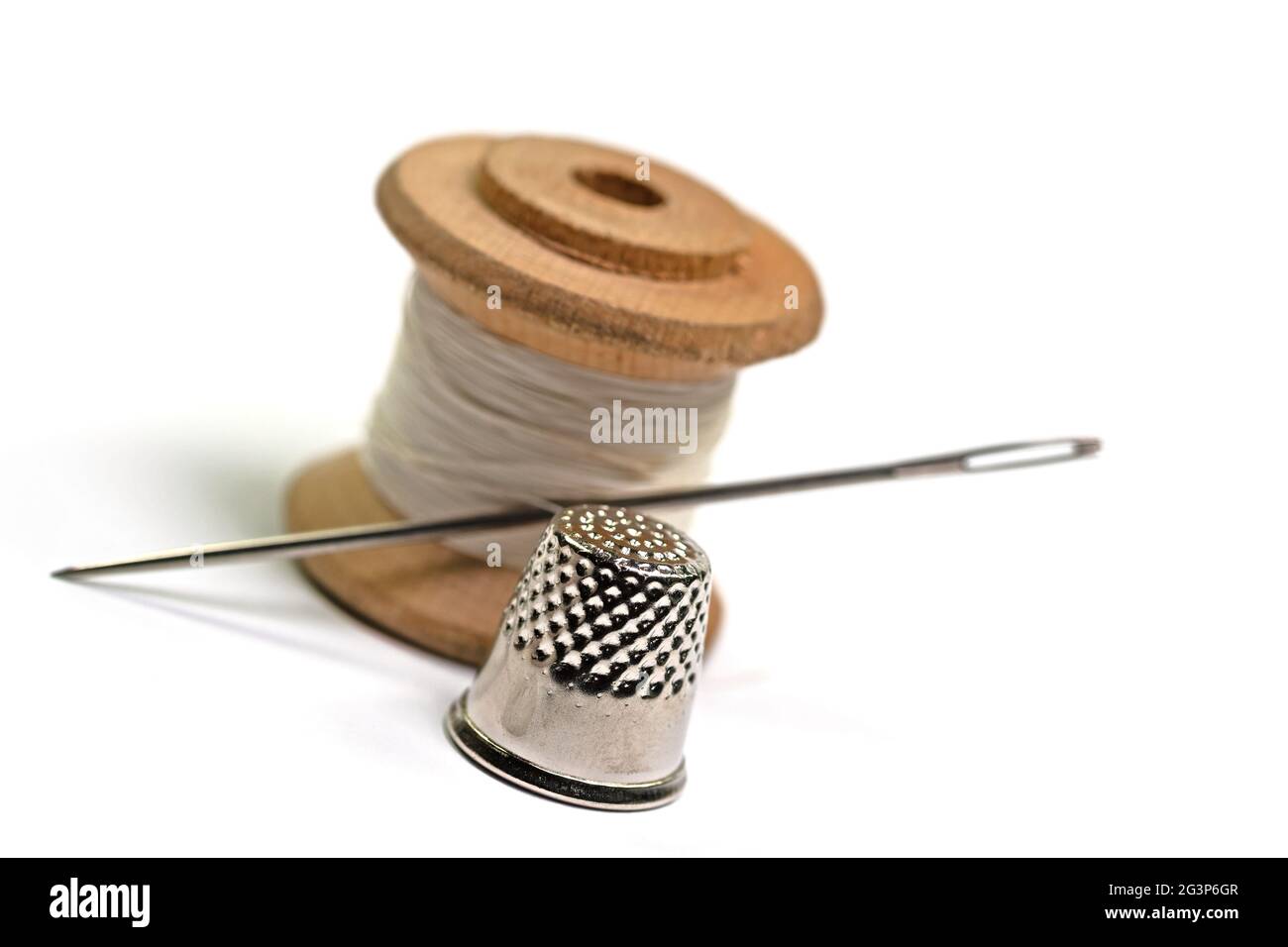 Ago per cucire e filo su fondo bianco Foto Stock