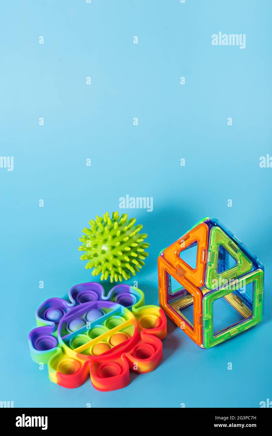 Rainbow Pop IT e il designer magnetico per bambini per lo sviluppo di abilità motorie, pensiero e immaginazione. Costruzione assemblata su un giocattolo rosa fidget o Foto Stock