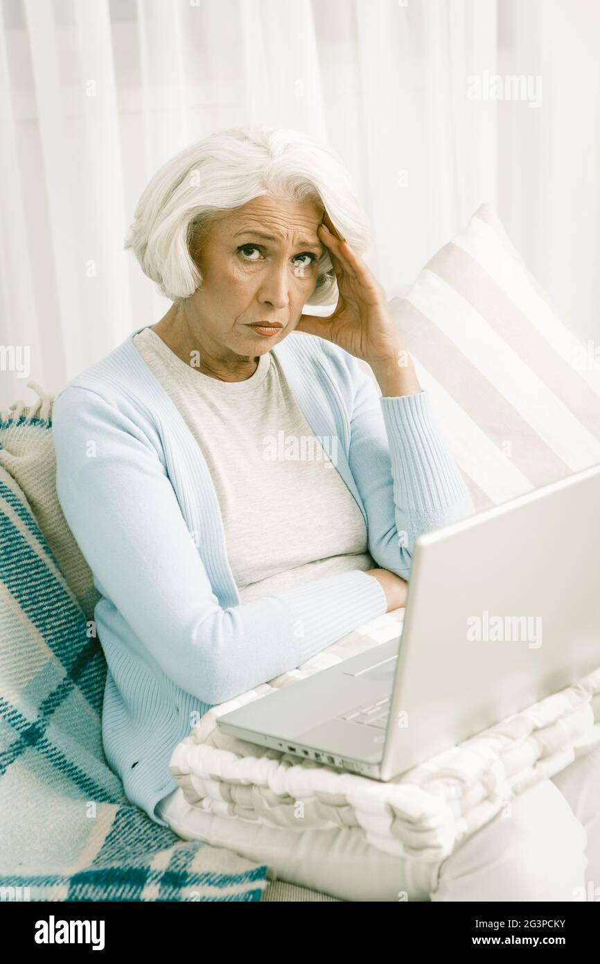 Donna anziana dai capelli grigi con notebook Foto Stock