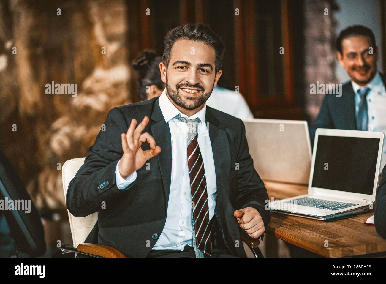 Il Business Person intelligente mostra OK Sign-posing presso la fotocamera Foto Stock
