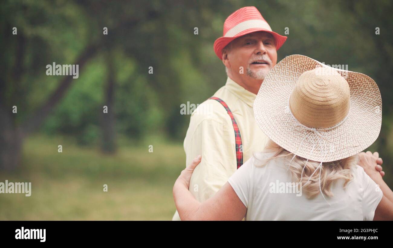 L'uomo anziano e la donna che ballano nel giardino Foto Stock