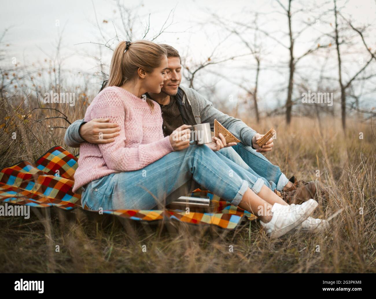 I viaggiatori sorridenti si rilassano seduti su Grass Foto Stock