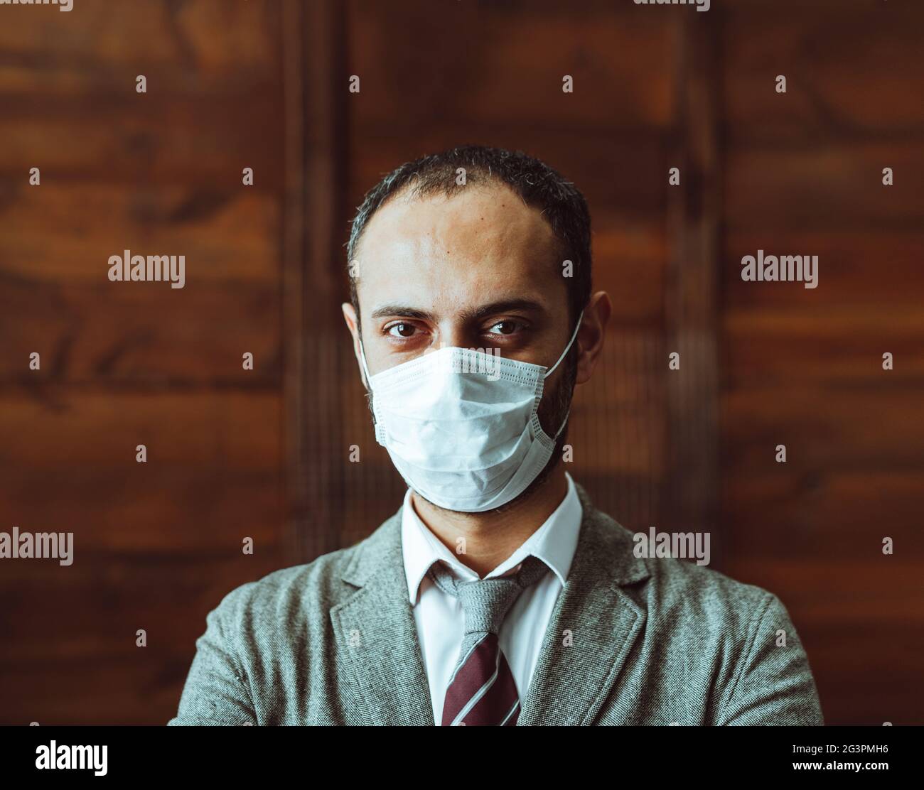 Fiducia uomo in maschera protettiva Stand alone in Office Foto Stock