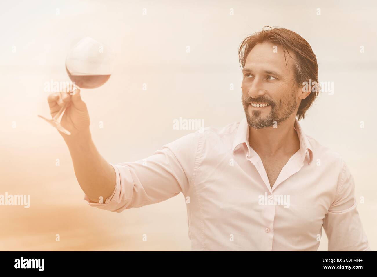 Concetto sommelier. Uomo con bicchiere di vino rosso. Buon sorriso per il produttore di vino Foto Stock