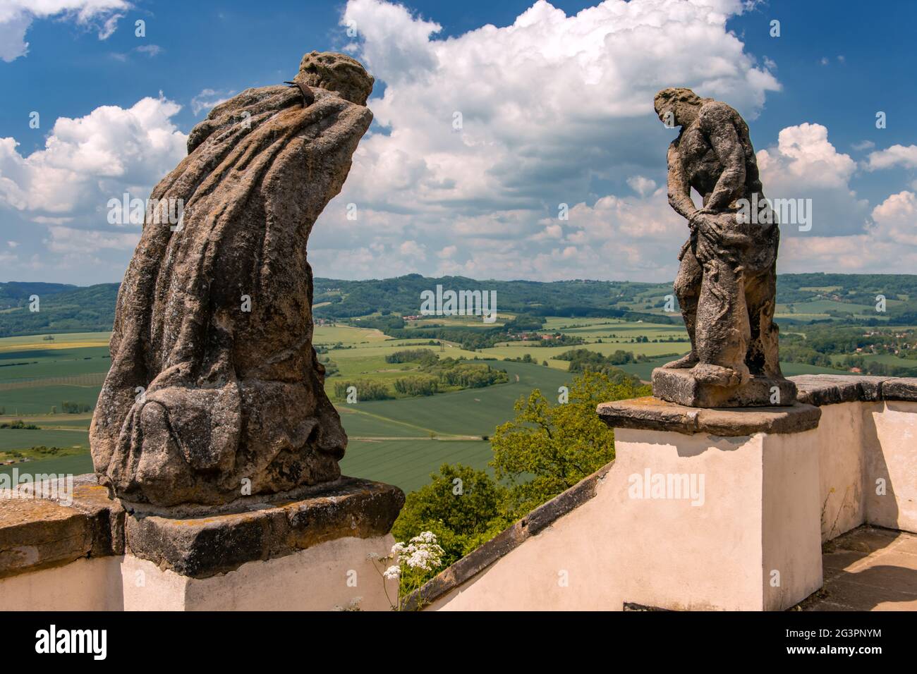Statue barocche - il flagello di Cristo e Gesù che cadono sotto la croce che domina il paesaggio. Foto Stock