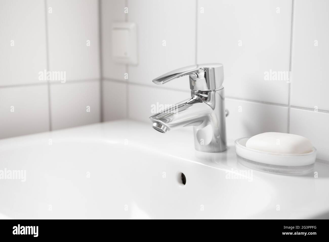 Lavello in ceramica bianca con rubinetto e sapone Foto Stock