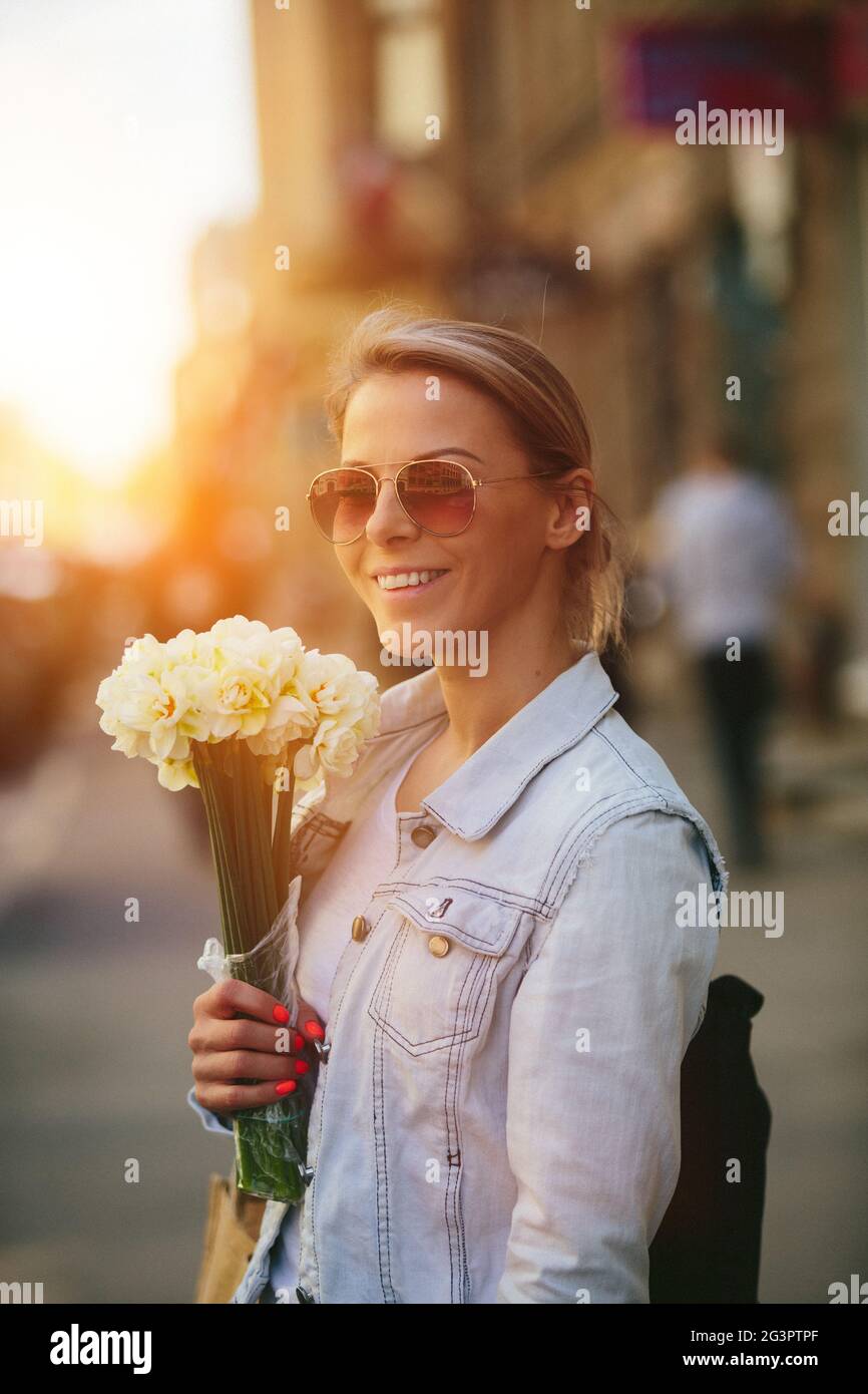 Bella e giovane donna con un bouquet di narcisi Foto Stock
