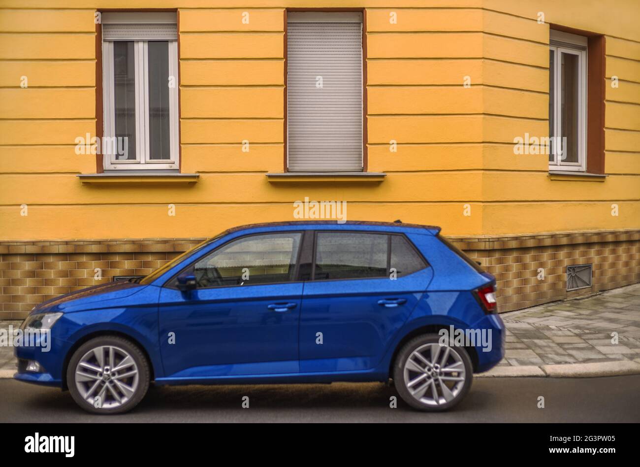 I colori giallo-arancio e blu - una macchina di fronte alla casa Foto Stock