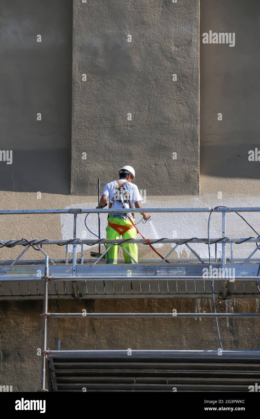 Lavoratori che sfregano la parete esterna dell'edificio Foto Stock