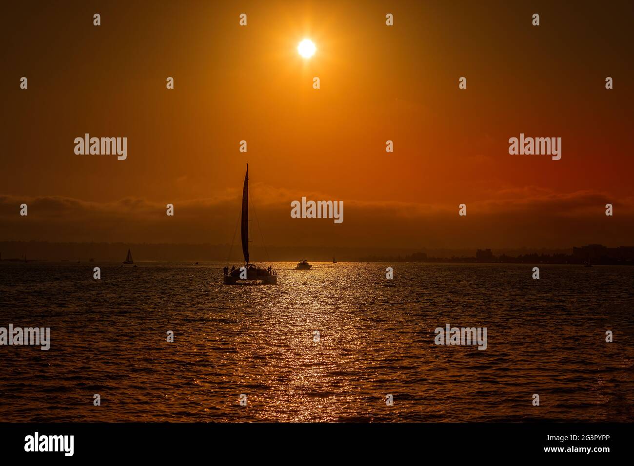 Tramonto dietro la silhouette di un catamarano a vela a San Diego Foto Stock