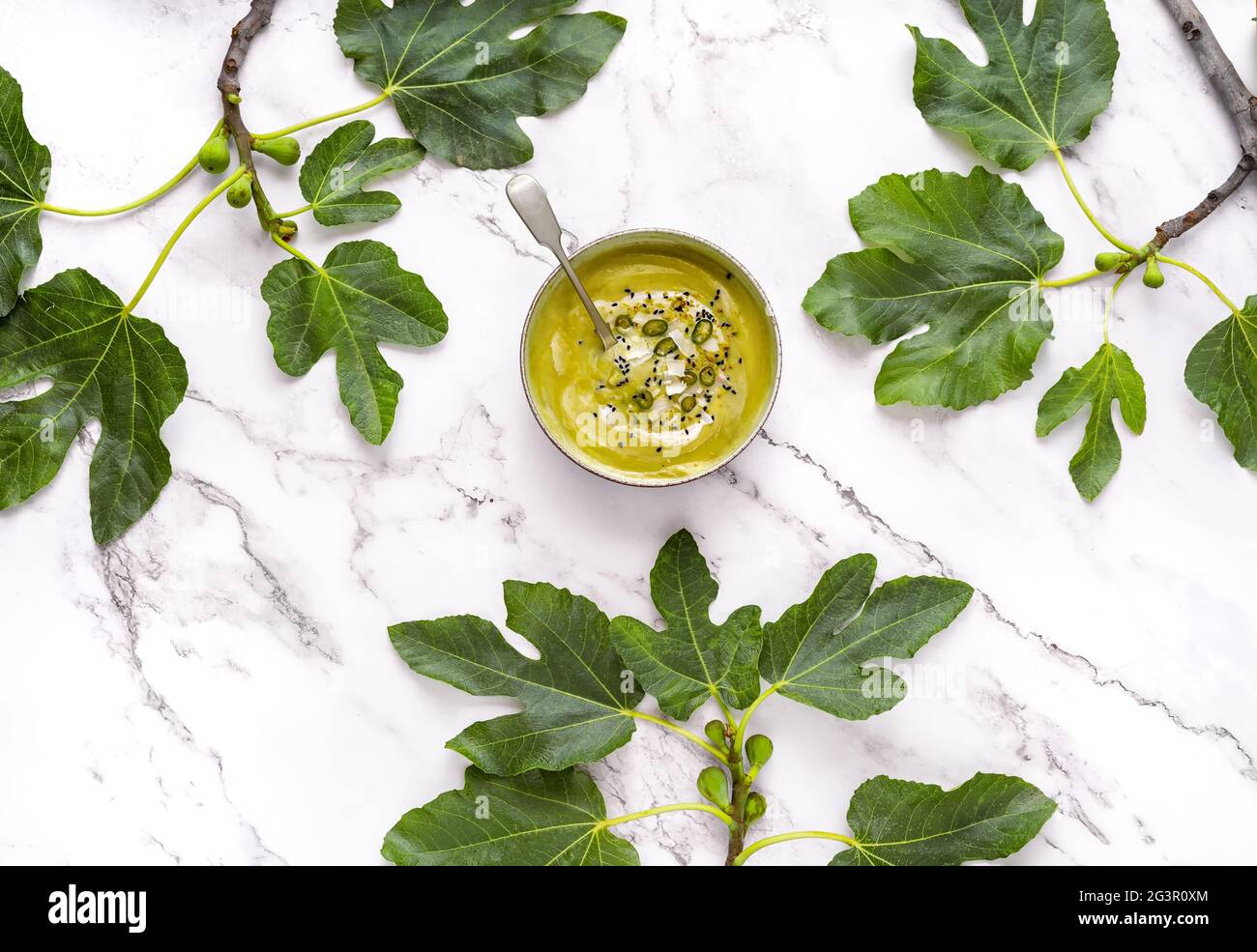 La fotografia piatta di una zuppa di crema vegana su un tavolo di marmo. Ricetta di verdure di una zuppa fredda estiva. Vista dall'alto di una purea di prodotti di stagione tra Foto Stock