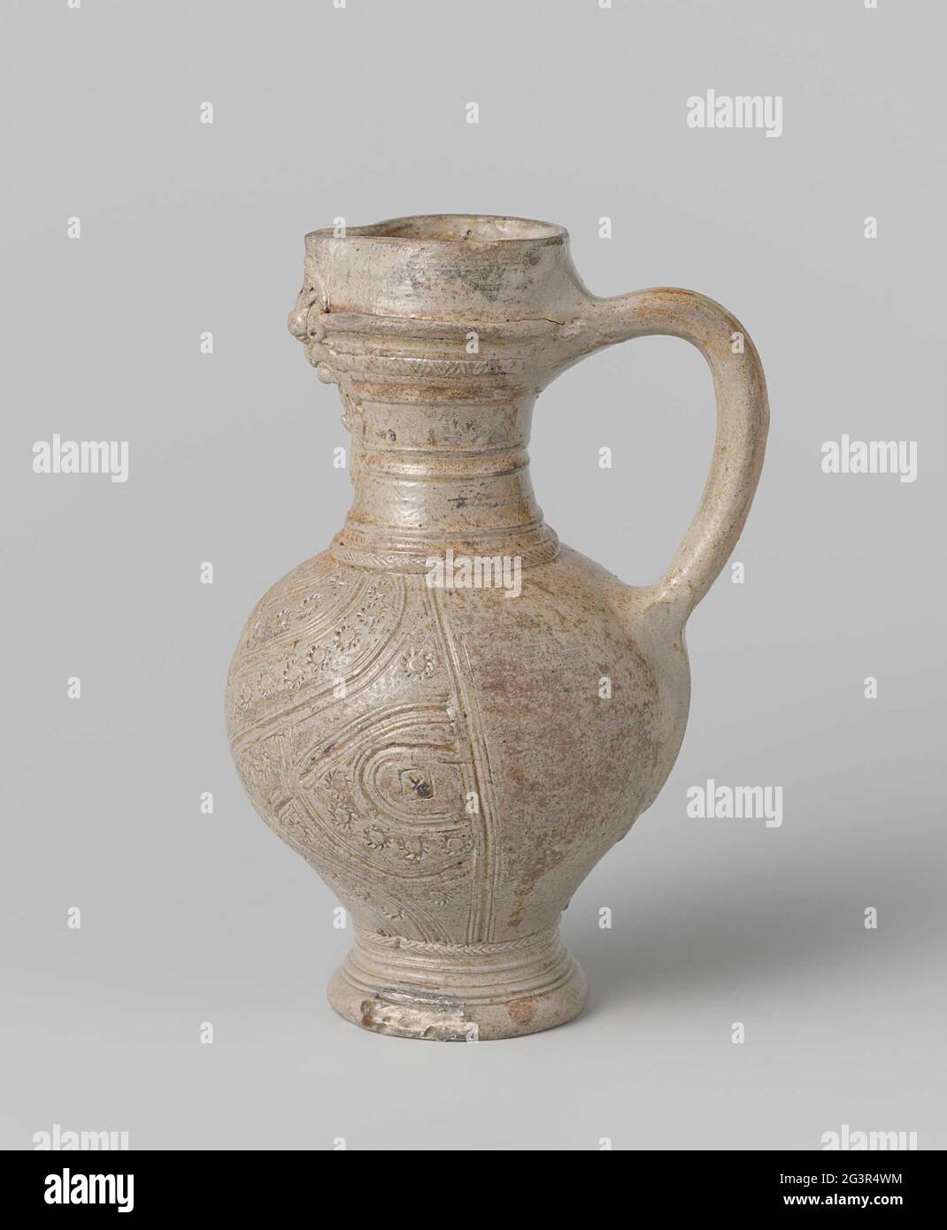 Caraffa di gres. Al contrario, brocca di gres. La caraffa ha un piede profilato e un orecchio a C. Il collo è cilindrico concavo e ha un bordo superiore alto con un beccuccio schiacciato. Il collo è in rilievo decorato con una barba. Il ventre è decorato con pneumatici ondulati stampati, tra cui rosette rotolanti e al centro sopra il bordo scintillante del piede una palma. Foto Stock