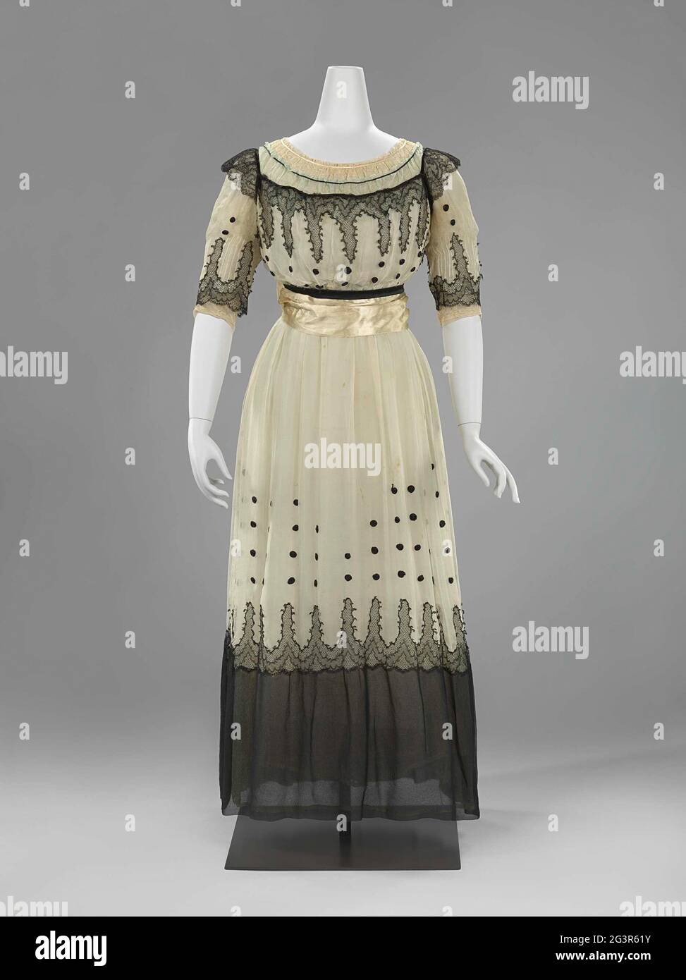 Jap di tre strati di Georgette crepe. L'abito è composto da tre georgette crespate rivestite l'una sull'altra; un abito a scivola bianco, un crock 'eau de nil' e un abito bianco con nero. Di conseguenza, il tutto è stato illuminato da un bagliore blu-verde. In linea di tendenza, i cerchi in raso nero arrotolato sulla gonna bianca e le frange annodate in bianco e nero sulla cintura. La gonna è libera dai piedi e abbastanza spaziosa per una sufficiente libertà di movimento. Foto Stock