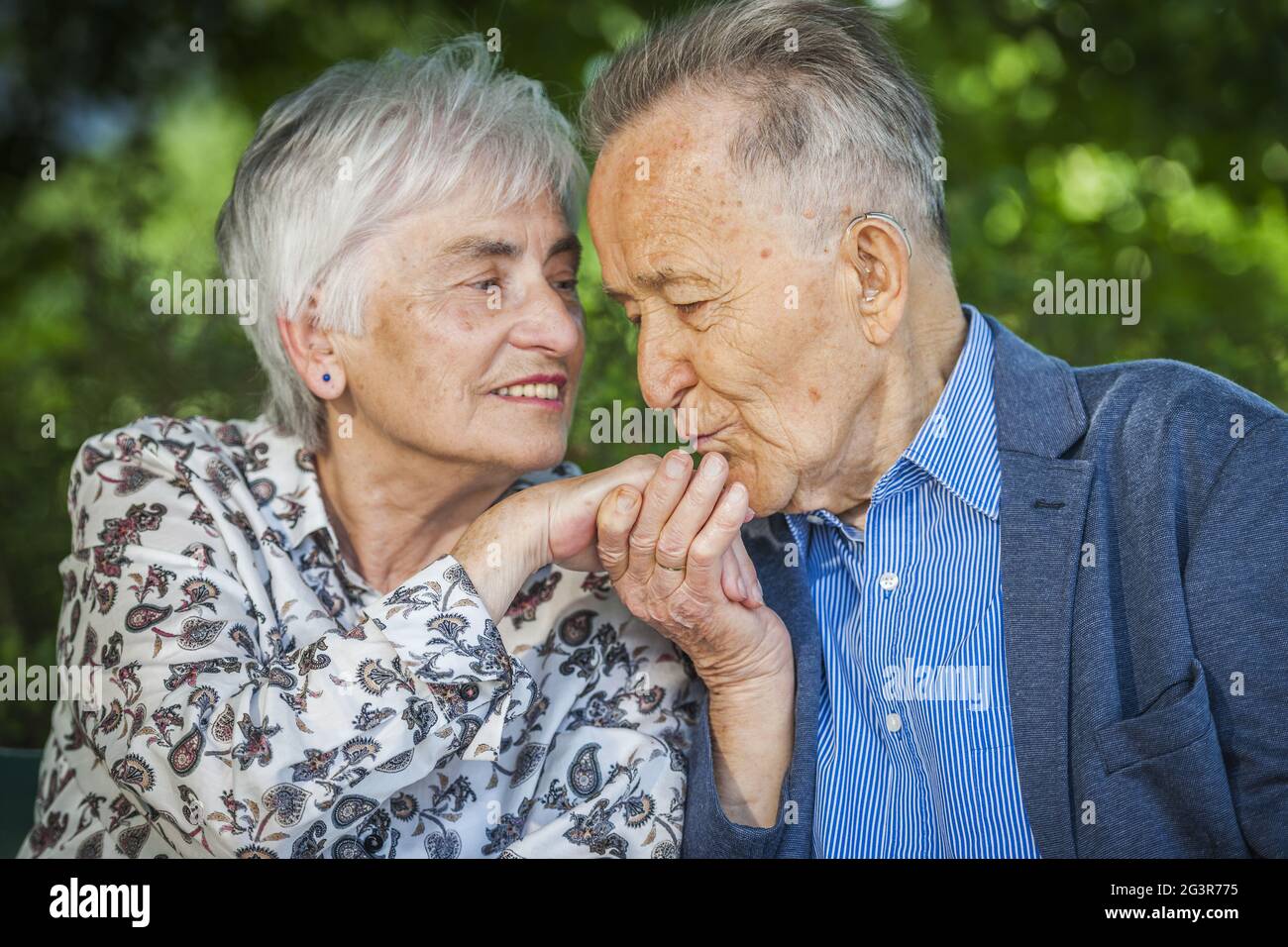 Felice mano bacio anziani Foto Stock